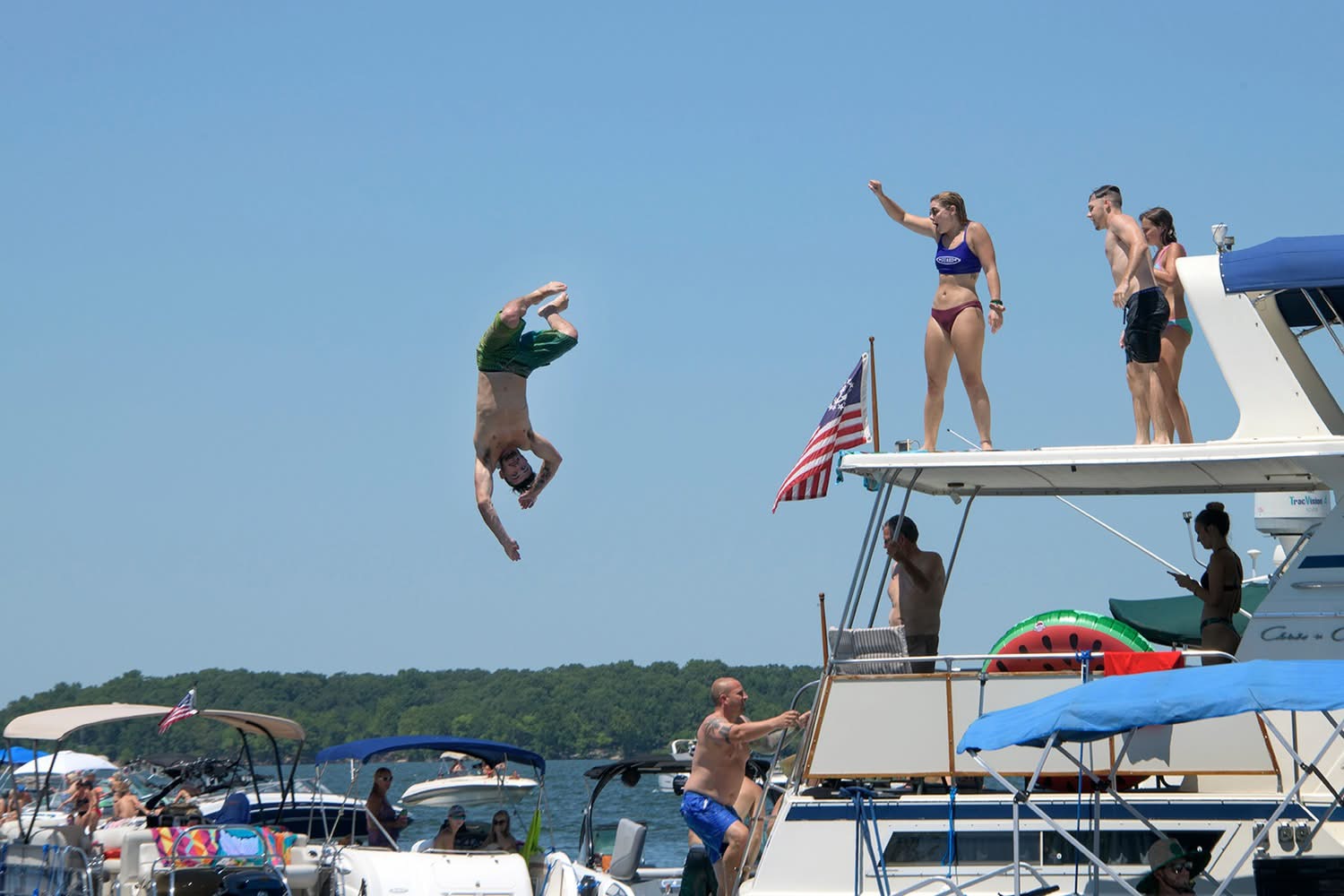 Man performing a backflip off the top deck of a houseboat into Grand Lake