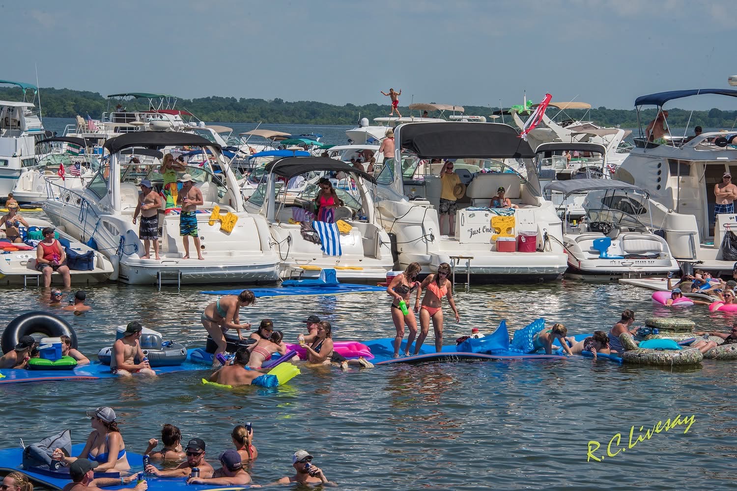 Dozens of boats rafted together with swimmers on floats in Grand Lake Party Cove